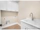 Functional laundry room featuring a sink, white cabinets, ample storage, and wood-look flooring at 154 Fox Hunt Dr, Mooresville, NC 28117