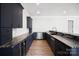 Chic wet bar featuring dark cabinets, marble countertops, and modern stainless steel appliances at 154 Fox Hunt Dr, Mooresville, NC 28117