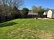 Large fenced backyard with lush green grass and stone firepit area at 1638 Marmot Pl, Concord, NC 28025