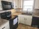 Kitchen features black appliances, light countertops and cream-colored cabinets at 1638 Marmot Pl, Concord, NC 28025