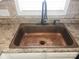 Close-up of a unique hammered copper kitchen sink with gooseneck faucet at 1638 Marmot Pl, Concord, NC 28025