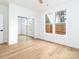 Bright bedroom featuring wood-look flooring, sliding mirrored closet doors, and large windows at 205 Skyline Cir, Salisbury, NC 28146
