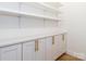 Organized pantry with white cabinets, modern gold hardware, and open shelving for optimal storage solutions at 205 Skyline Cir, Salisbury, NC 28146