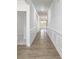 Long hallway with hardwood floors and decorative wainscoting, leading to other rooms at 2058 Skyhawk Dr, Lake Wylie, SC 29745