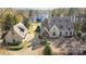 Aerial view of the stone clad home with an oversized driveway and detached garage near a lake at 20711 Bethel Church Rd, Cornelius, NC 28031