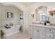 Elegant bathroom with a freestanding tub, a large mirror, sconces, and a marble countertop vanity at 20711 Bethel Church Rd, Cornelius, NC 28031