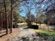 Gated driveway leading to a private estate, surrounded by mature trees and lush greenery at 20711 Bethel Church Rd, Cornelius, NC 28031