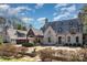 Stunning stone home featuring a porte-cochere, gabled roof, and lush landscaping for an elegant, timeless look at 20711 Bethel Church Rd, Cornelius, NC 28031