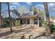 Charming stone cottage featuring a stone chimney, covered porch, and fire pit in the front yard at 20711 Bethel Church Rd, Cornelius, NC 28031