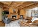 Cozy living room featuring a stone fireplace, custom wood paneling, and sophisticated decor at 20711 Bethel Church Rd, Cornelius, NC 28031