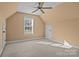Bright bedroom under the roofline with neutral walls and carpet, featuring a window with blinds and a ceiling fan at 214 Harbor Landing Dr, Mooresville, NC 28117