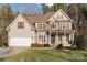 Beautiful home boasts a two-car garage, well-maintained lawn, and inviting front porch at 214 Harbor Landing Dr, Mooresville, NC 28117