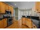 Bright kitchen with hardwood floors, oak cabinets, granite countertops, and modern stainless steel appliances at 214 Harbor Landing Dr, Mooresville, NC 28117