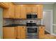 Cozy kitchen with wooden cabinets, stainless steel appliances, and dark countertops at 214 Harbor Landing Dr, Mooresville, NC 28117