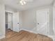 Bright bedroom boasts hardwood floors, ceiling fan and doors to closet and hall at 290 Houston Ne St, Concord, NC 28025