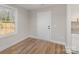 A view of the entryway, featuring hardwood floors, white trim, a white door, and a window offering natural light at 290 Houston Ne St, Concord, NC 28025