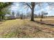 Spacious backyard with mature trees and partial fencing at 308 W Charlotte Ave, Mount Holly, NC 28120