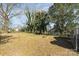 Large, partially fenced backyard with mature trees and a fire pit at 308 W Charlotte Ave, Mount Holly, NC 28120