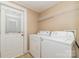 Functional laundry room with washer, dryer, storage shelf and door to the backyard at 308 W Charlotte Ave, Mount Holly, NC 28120