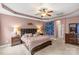 Relaxing primary bedroom featuring a tray ceiling, fan, plush bed, and ensuite bathroom at 3090 Tallgrass Blf, Rock Hill, SC 29732