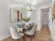 Dining room featuring modern chandelier, dining table, and neutral decor at 3314 Cedarhurst Dr, Charlotte, NC 28269