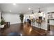 Open-concept living room with hardwood floors and a breakfast bar leading to the kitchen at 3501 Winterfield Pl, Charlotte, NC 28205