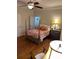 Inviting bedroom features a four-poster bed with colorful bedding, ceiling fan and classic wooden floors at 400 Martin Luther King Jr Ave, Kannapolis, NC 28083