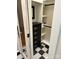 Organized closet with built-in drawers, custom shelving, and a glass paned door, atop black and white tile at 400 Martin Luther King Jr Ave, Kannapolis, NC 28083