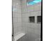 Modern walk-in shower featuring white tiles, built-in bench, and recessed shelving at 400 Martin Luther King Jr Ave, Kannapolis, NC 28083