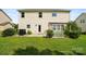 A spacious backyard featuring a lush lawn, patio area, and charming arbor swing with beautiful landscaping at 5006 Sand Trap Ct # 142, Monroe, NC 28112