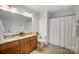 Bright bathroom featuring a double sink vanity with granite countertop and shower with curtain at 5006 Sand Trap Ct # 142, Monroe, NC 28112