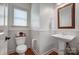 Cozy half bathroom with pedestal sink, decorative mirror, and wainscoting at 5006 Sand Trap Ct # 142, Monroe, NC 28112