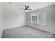 Bright bedroom with a ceiling fan, carpet, and a window offering natural light and neighborhood views at 5006 Sand Trap Ct # 142, Monroe, NC 28112