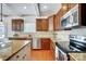 Modern kitchen with stainless steel appliances, granite countertops, wooden cabinets, and hardwood floors at 5006 Sand Trap Ct # 142, Monroe, NC 28112