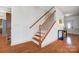 A staircase with wooden handrails, spindles, and hardwood floors leads to the upper level at 5006 Sand Trap Ct # 142, Monroe, NC 28112
