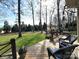 Wood deck with outdoor seating overlooking a spacious yard and trees at 6301 Royal Aberdeen Ct, Charlotte, NC 28277