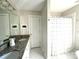 Bright bathroom featuring double sinks with granite counters and a shower with white-striped curtain at 6301 Royal Aberdeen Ct, Charlotte, NC 28277