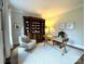 Stylish home office with a large bookcase, comfortable seating, and a classic wooden desk at 6301 Royal Aberdeen Ct, Charlotte, NC 28277