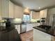 Modern kitchen with stainless steel appliances, black countertops, and ample white cabinetry at 6301 Royal Aberdeen Ct, Charlotte, NC 28277