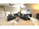 Spacious attic living room with a large sectional sofa, windows, and two ceiling fans at 6301 Royal Aberdeen Ct, Charlotte, NC 28277
