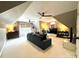 Spacious, finished attic space featuring a modular sofa, mounted TV, and dual ceiling fans at 6301 Royal Aberdeen Ct, Charlotte, NC 28277