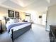 Spacious main bedroom featuring plush carpeting, a tray ceiling, and large windows at 6301 Royal Aberdeen Ct, Charlotte, NC 28277