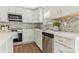 Modern kitchen with stainless steel appliances, white cabinets, quartz counters, and tiled backsplash at 733 Rocky Grove Gln, York, SC 29745