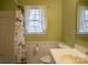 Bright bathroom with white wainscoting, sink, toilet, and a shower curtain at 7708 Ritter Dr, Charlotte, NC 28270