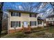 Traditional two-story home with black shutters, a brick foundation, and a welcoming front porch leading to the front door at 7708 Ritter Dr, Charlotte, NC 28270