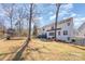 A spacious backyard includes a trampoline, a foot bridge, a treehouse, and a seating area with a fire pit at 7732 Wingmont Dr, Charlotte, NC 28269