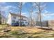 Large backyard with a deck, trampoline, patio seating area, and a small foot bridge in a lush outdoor setting at 7732 Wingmont Dr, Charlotte, NC 28269