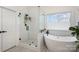 Modern bathroom featuring a glass-enclosed shower and a soaking tub, complemented by white subway tile and natural light at 7732 Wingmont Dr, Charlotte, NC 28269