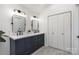 Bright bathroom featuring a double vanity with modern fixtures and a spacious closet at 7732 Wingmont Dr, Charlotte, NC 28269