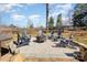 Outdoor fire pit with Adirondack chairs in a pea gravel bed with brick border, perfect for gatherings and relaxing outdoors at 7732 Wingmont Dr, Charlotte, NC 28269